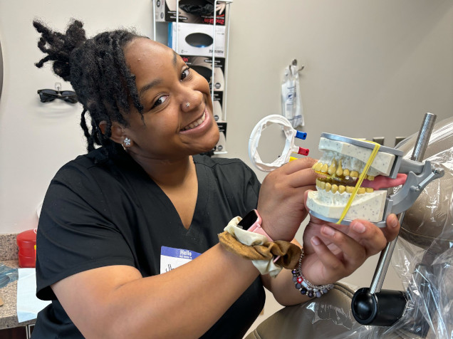 {{ school.name }} student posing with a dental mold for assistant training {{ school.name }} student posing with a dental mold for assistant training