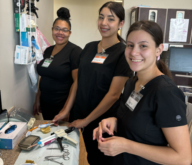 {{ school.name }} students working with dental assisting equipment in class {{ school.name }} students working with dental assisting equipment in class